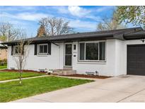 Charming single-story home with white brick exterior, well-manicured lawn and concrete driveway at 3103 W Bellewood Dr, Englewood, CO 80110