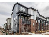 Modern townhome with gray siding, brick accents, and covered porch at 1342 Independence St # 6, Lakewood, CO 80215