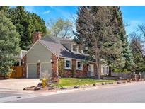 Charming two-story brick home with a well-manicured lawn, mature trees, and an attached two-car garage at 6302 S Ivy Ct, Centennial, CO 80111