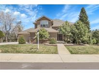 Charming two-story home with a well-maintained lawn and mature trees, creating a welcoming curb appeal at 3266 Coyote Hills Way, Castle Rock, CO 80109