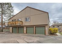Neutral two-story condo featuring individual garages and an upper-level wooden balcony at 7700 W Glasgow Pl # 6C, Littleton, CO 80128
