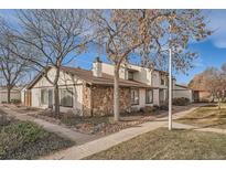 Charming townhome featuring stone accents and neutral siding on a well-maintained lot with mature trees and sidewalks at 16036 E Ithaca Pl # E, Aurora, CO 80013