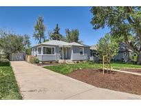 Charming single-story home with a well-manicured lawn and a concrete driveway leading to a detached garage at 3975 S Logan St, Englewood, CO 80113
