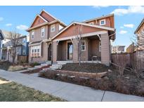 Charming two-story home with a covered front porch and well-manicured landscaping at 7976 E 53Rd Dr, Denver, CO 80238