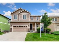 Inviting two-story home with a well-maintained lawn and a charming stone-accented facade at 3565 E 141St Dr, Thornton, CO 80602