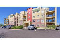 A modern condo building with balconies, brick accents, and ample parking on a clear, sunny day at 1044 Rockhurst Dr # 401, Highlands Ranch, CO 80129