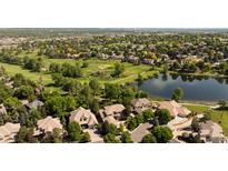 Aerial view of homes and golf course, surrounded by lush green trees and a lake at 2535 W 115Th Dr, Westminster, CO 80234