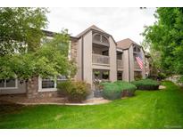 Inviting condo exterior featuring a lush lawn and two-story facade with quaint balcony at 9263 E Arbor Cir # B, Englewood, CO 80111