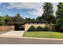 Mid-century modern home with brick facade, covered carport, and well-maintained lawn at 6080 S Detroit St, Centennial, CO 80121