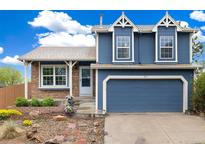 Charming two-story home features a blue exterior, attached garage, and manicured landscaping at 325 Mulberry Cir, Broomfield, CO 80020