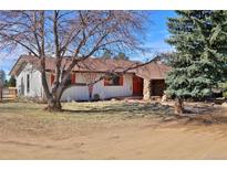 Charming ranch-style home featuring stone accents, a landscaped yard, and a serene, inviting atmosphere at 1340 Deerpath Trl, Franktown, CO 80116