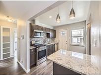 Charming kitchen featuring modern appliances, ample counter space, stylish backsplash, and convenient island at 3259 N Adams St, Denver, CO 80205