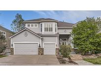 Charming two-story home showcasing a 3-car garage, landscaped yard, and inviting entrance at 10456 Carriage Club Dr, Lone Tree, CO 80124