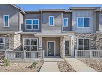 Charming townhome showcasing stone accents, gray siding, and inviting front porch perfect for relaxation at 1986 S Haleyville Way, Aurora, CO 80018