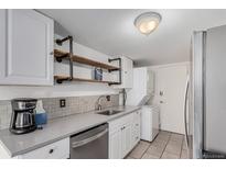 Bright kitchen with modern appliances, laundry machine and custom shelving at 7904 Chase Cir # 146, Arvada, CO 80003