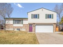 Charming two-story home featuring a purple front door, brick accents, and an attached two-car garage at 1812 24Th Ave, Longmont, CO 80501