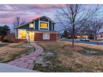 Charming two-story home featuring a brick facade, green siding, and a welcoming stone pathway at 375 Aspenwood Ct, Lafayette, CO 80026
