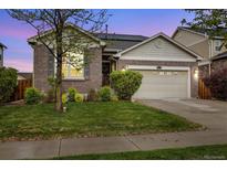 Inviting single-Gathering home features a brick exterior, well-manicured lawn, and an attached two-car garage at 25811 E Archer Ave, Aurora, CO 80018