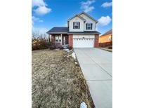 Two-story home featuring a brick facade, attached two-car garage, covered front porch, and a well-manicured lawn at 25952 E 5Th Pl, Aurora, CO 80018