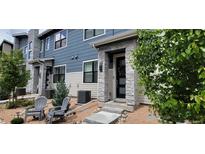 Charming two-story home featuring modern architectural design, stone accents, and a cozy front patio with seating at 9279 Merino Ct # B, Littleton, CO 80125