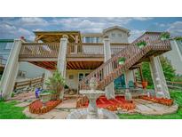 Charming backyard featuring a multi-tiered deck, fountain, and lush landscaping at 9832 N Crystal Lake Dr, Littleton, CO 80125
