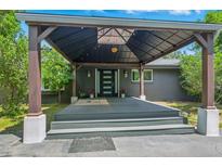 Inviting home entrance with a covered porch, sleek front door, and stylish exterior details at 6505 W Hampden Ave, Lakewood, CO 80227