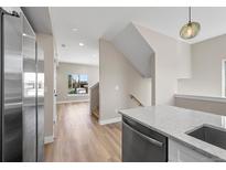 Modern kitchen featuring stainless steel appliances, quartz countertops, and light hardwood flooring at 2140 S Ash St # 105, Denver, CO 80222