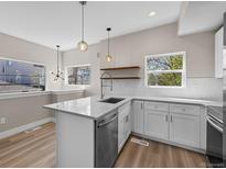 Modern kitchen showcasing white cabinets, quartz countertops, stainless steel appliances, and a stylish breakfast bar at 2140 S Ash St # 105, Denver, CO 80222
