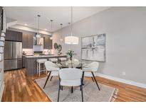 Stylish dining area with modern lighting, seating, and a view into the adjacent kitchen at 4144 Tennyson St # 212, Denver, CO 80212