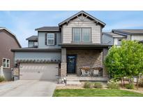 Charming two-story home with a stone-accented front porch and well-manicured lawn at 19121 E 65Th Ave, Denver, CO 80249