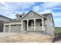 Charming home featuring a welcoming front porch, complemented by a two-car garage and stone accents at 3895 Buttongrass Trl, Castle Rock, CO 80108