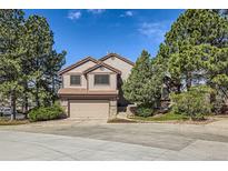 Charming two-story home with attached garage, mature trees, and landscaped front yard at 187 W Prestwick Ct, Castle Rock, CO 80104