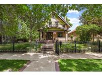Charming home featuring a manicured lawn, iron fence, and inviting facade at 2716 N Vine St, Denver, CO 80205