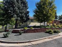 Landscaped front yard with curb appeal and a brick retaining wall at 4550 S Elati St, Englewood, CO 80110