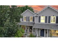 Two-story house with gray siding, navy door, and a well-manicured lawn at 2456 S Marion St, Denver, CO 80210