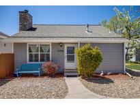 Charming single story home with stone chimney, walkway, and a cozy blue bench at 12780 E Bethany Pl, Aurora, CO 80014