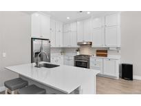 Bright kitchen features white cabinetry, stainless steel appliances, an island, and sleek countertops at 12214 Stone Timber Ct, Parker, CO 80134