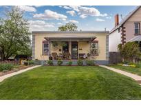 Charming home featuring a well-manicured lawn, inviting porch, and colorful facade, perfect for a cozy curb appeal at 4528 W 34Th Ave, Denver, CO 80212