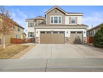 Traditional two-story home featuring a three-car garage and nicely landscaped yard at 14284 Double Dutch Cir, Parker, CO 80134