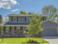 Charming two-story home with a manicured lawn and an attached two-car garage at 4196 S Reading Way, Denver, CO 80237