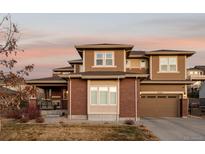 Beautiful two-story home featuring a brick facade, craftsman details, and a two-car garage at sunset at 27274 E Lakeview Pl, Aurora, CO 80016
