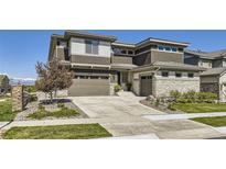Stunning exterior showcasing the home's architecture, landscaping, and mountain views in the distance at 16345 Spanish Peak Way, Broomfield, CO 80023