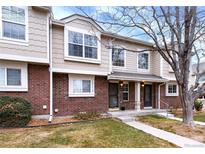 Inviting townhome with brick facade, neutral siding, and well-maintained front lawn at 18397 E Alabama Pl # D, Aurora, CO 80017