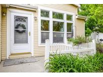 Charming home exterior featuring a white front door with a wreath and adjacent large window at 7725 Hummingbird Green # 78, Frederick, CO 80530