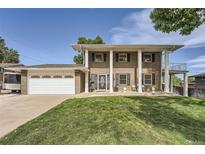 Brick ranch home with attached garage and manicured lawn at 13577 W Alaska Dr, Lakewood, CO 80228