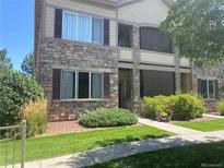 Beautiful exterior shot of this two-story home with stone facade and manicured lawn at 7170 S Wenatchee Way # C, Aurora, CO 80016