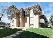 This exterior shows a two-story apartment building with a well-manicured lawn and a beautiful roof at 7455 E Quincy Ave # 204, Denver, CO 80237