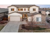 Inviting two-story home featuring a three-car garage, stone accents, and a well-manicured front yard at 11100 Pastel Pt, Parker, CO 80134