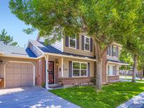 Charming two-story home with a brick facade and a well-manicured lawn, partially shaded by a mature tree at 4121 W 111Th Cir, Westminster, CO 80031