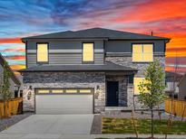 Two-story home with a stone and vinyl exterior, a two-car garage, and a well-manicured lawn at 6117 Camprock Way, Brighton, CO 80601